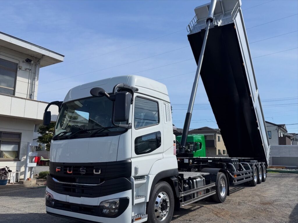 HARDOX製ダンプトレーラーを前方斜めから撮影。荷台を上げた状態でダンプ機構とトラクタを確認できる製作事例。