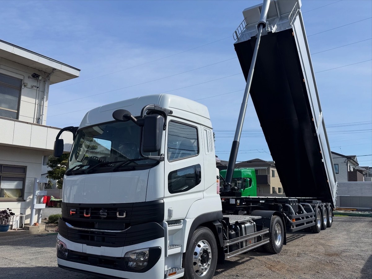 HARDOX製ダンプトレーラーを前方斜めから撮影。荷台を上げた状態でダンプ機構とトラクタを確認できる製作事例。
